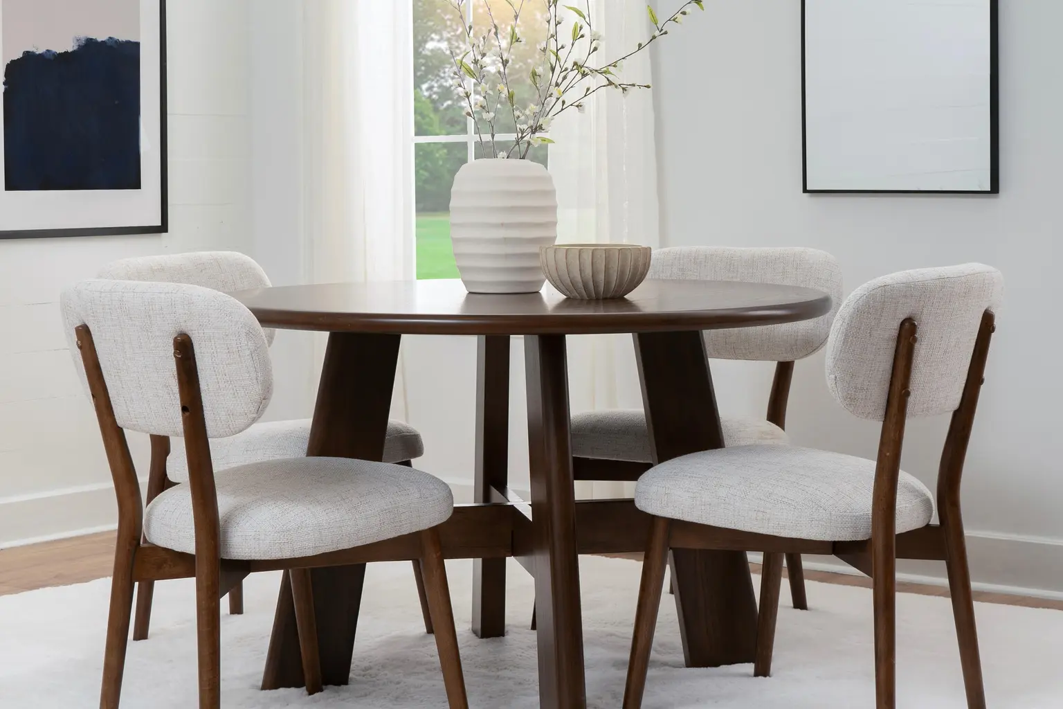Ashley Curran round walnut dining table with curved upholstered chairs