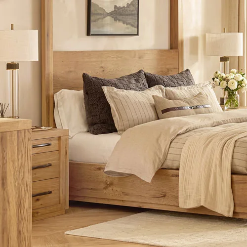 Natural wood bed with layered neutral bedding and matching nightstands