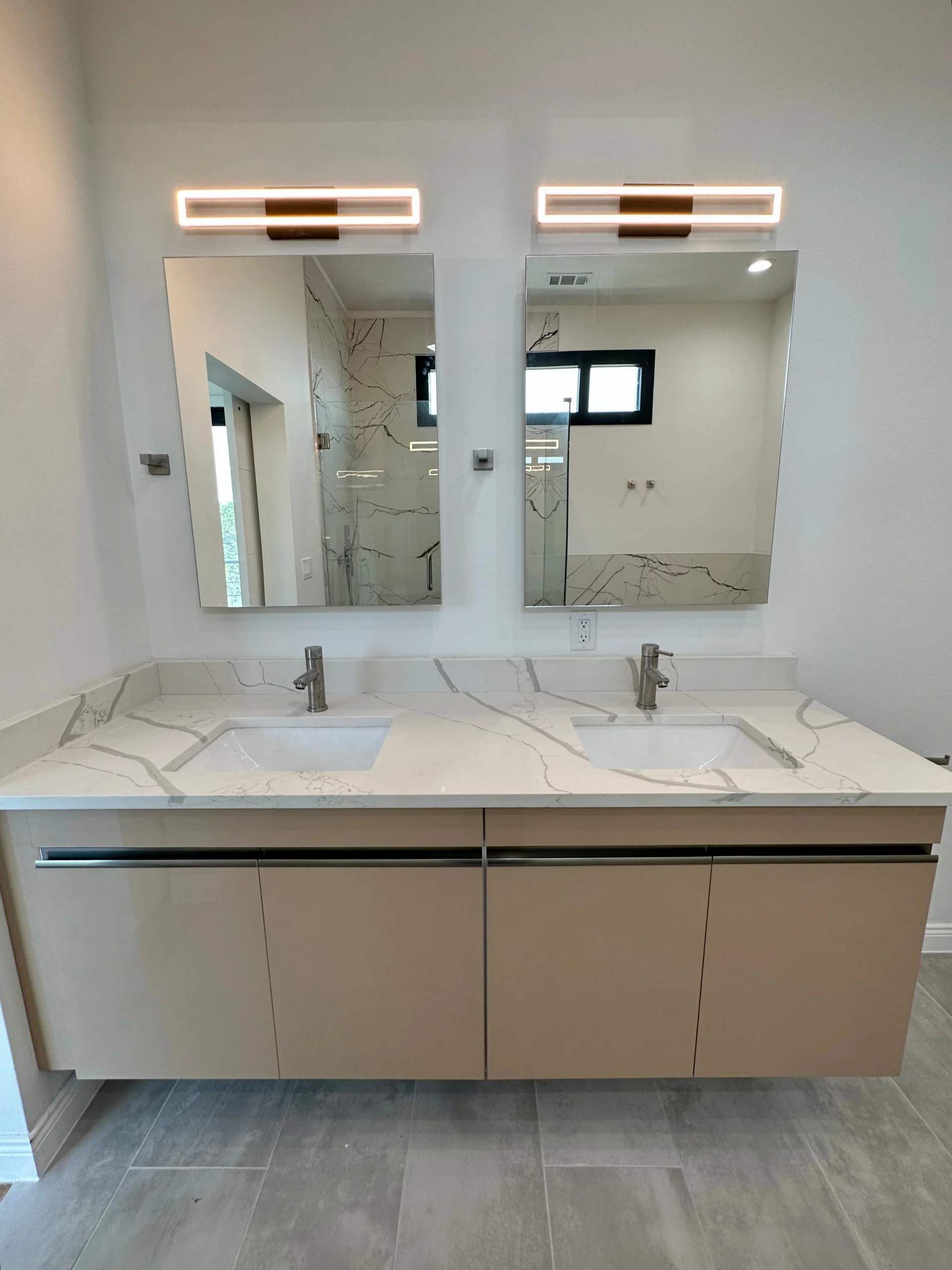 Double floating vanity with two mirrors and warm neutral cabinetry